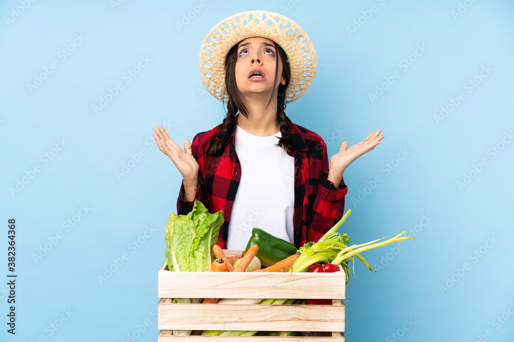 Young farmer Woman holding fresh vegetables in a wooden basket frustrated by a bad situation