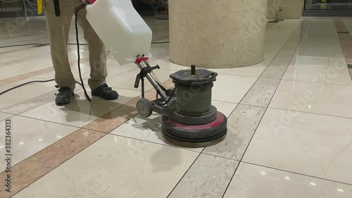 Marble floor polishing with a professional scrubber in office building lobby