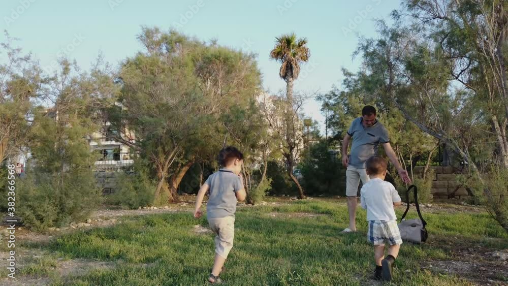 Father and sons playing in the park. High quality 4k footage Father and sons playing in the park. High quality 4k footage