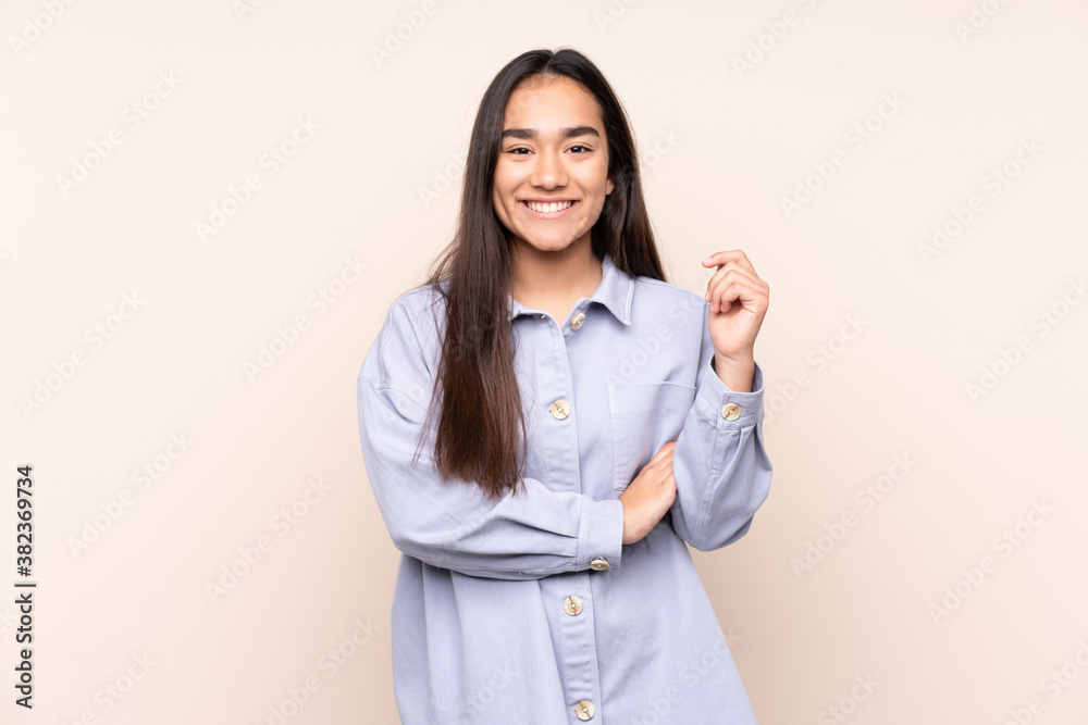 Young Indian woman isolated on beige background laughing Young Indian woman isolated on beige background laughing