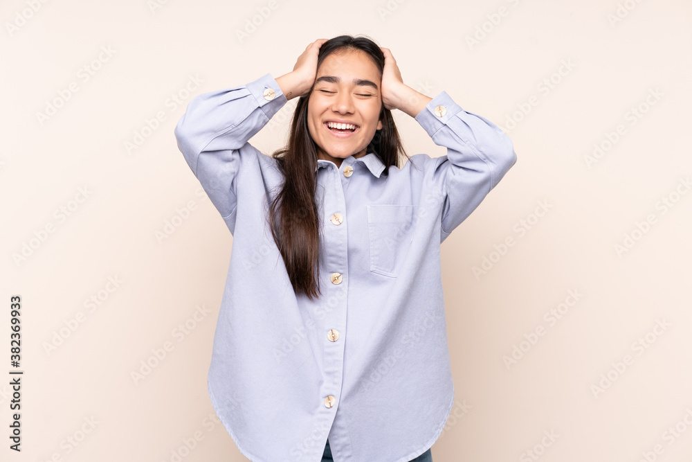 Young Indian woman isolated on beige background laughing Young Indian woman isolated on beige background laughing