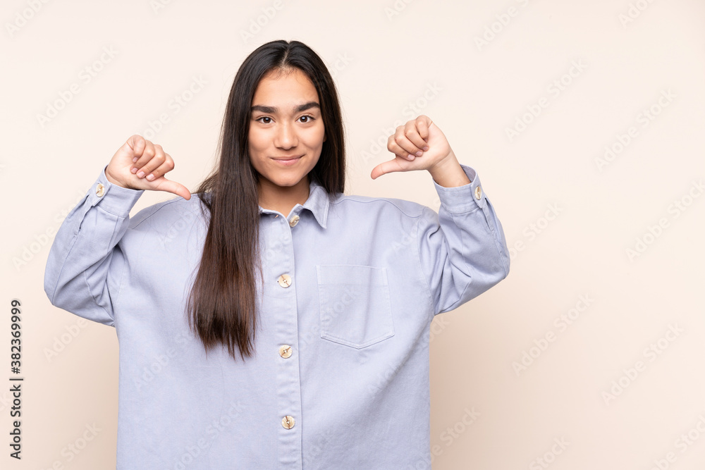 Young Indian woman isolated on beige background proud and self-satisfied Young Indian woman isolated on beige background proud and self-satisfied
