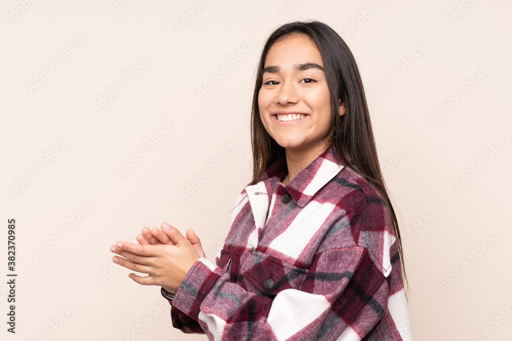 Young Indian woman isolated on beige background applauding Young Indian woman isolated on beige background applauding