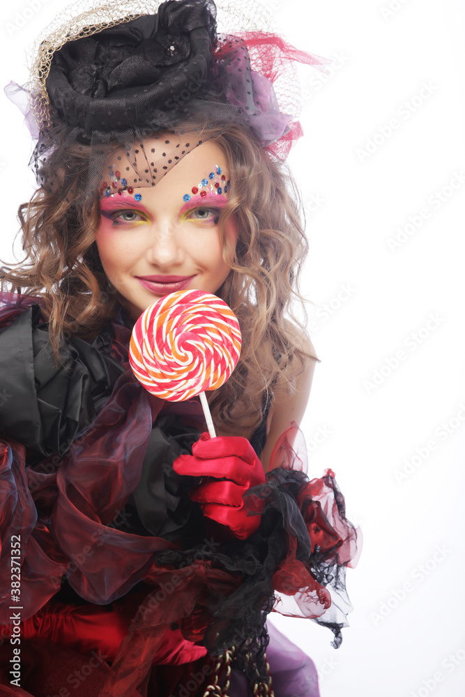 Girl with with creative make-up holds lollipop.