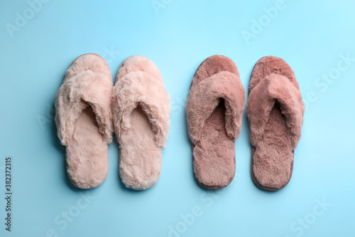 Different stylish soft slippers on light blue background, flat lay