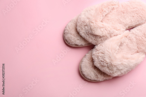 Pair of stylish soft slippers on pink background, flat lay. Space for text