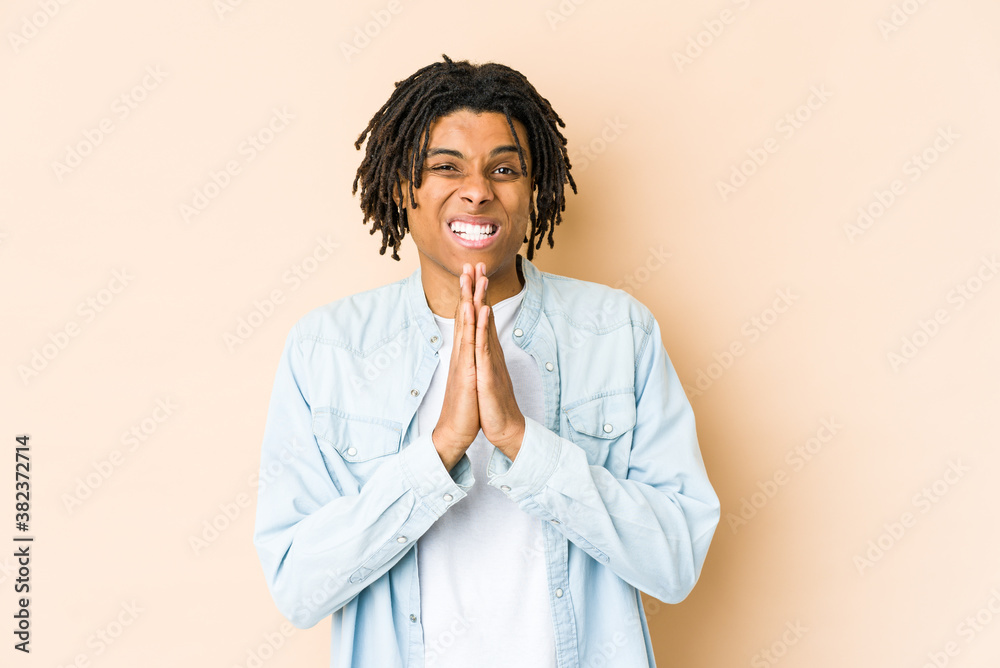 Young african american rasta man holding hands in pray near mouth, feels confident. Young african american rasta man holding hands in pray near mouth, feels confident.