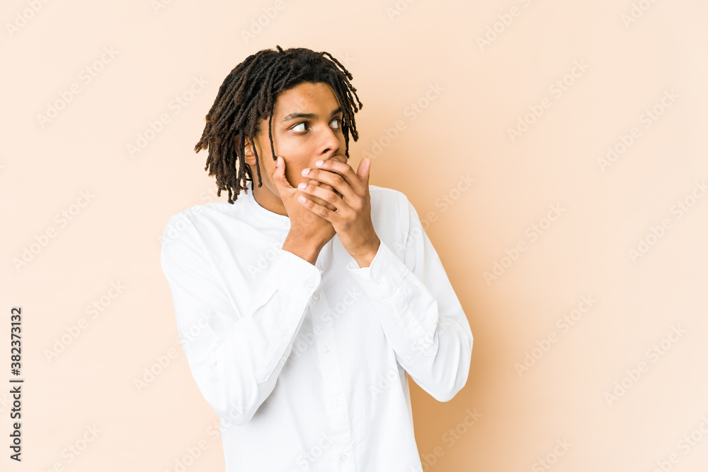 Young african american rasta man thoughtful looking to a copy space covering mouth with hand. Young african american rasta man thoughtful looking to a copy space covering mouth with hand.