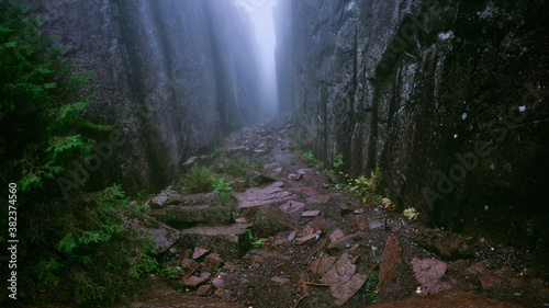 High cliffs on both sides at once leading away in foggy weather