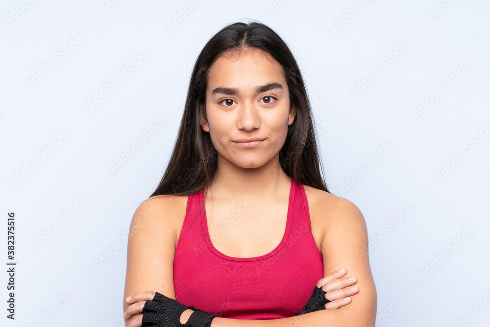 Young Indian sport woman isolated on blue background with arms crossed Young Indian sport woman isolated on blue background with arms crossed