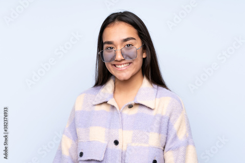 Young Indian woman isolated on blue background © luismolinero