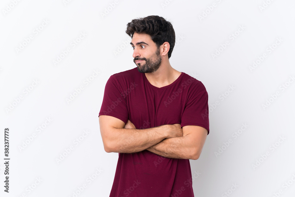 Young handsome man with beard over isolated white background making doubts gesture while lifting the shoulders Young handsome man with beard over isolated white background making doubts gesture while lifting the shoulders