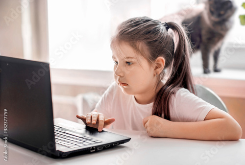 
sad little girl sitting at the computer
