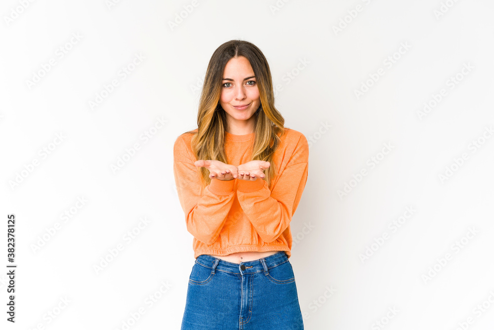Young caucasian woman isolated on white background holding something with palms, offering to camera. Young caucasian woman isolated on white background holding something with palms, offering to camera.