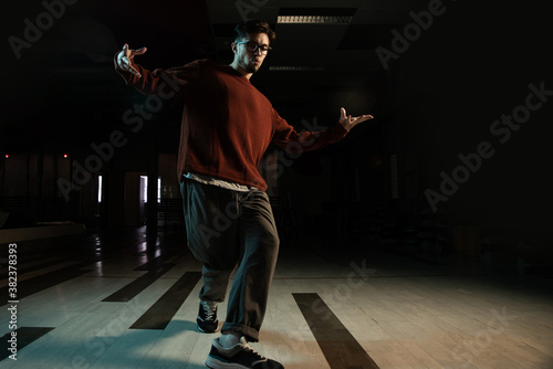 Professional break dancer posing in motion, practicing modern hip-hop dance in the studio