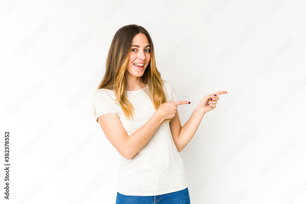 Obraz premium Young caucasian woman isolated on white background excited pointing with forefingers away.