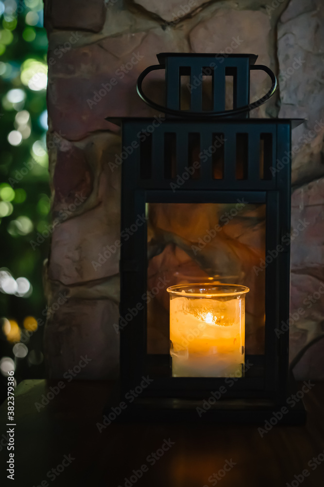 Glass jars with lit candle inside ,On dark wooden tables in coffee shop