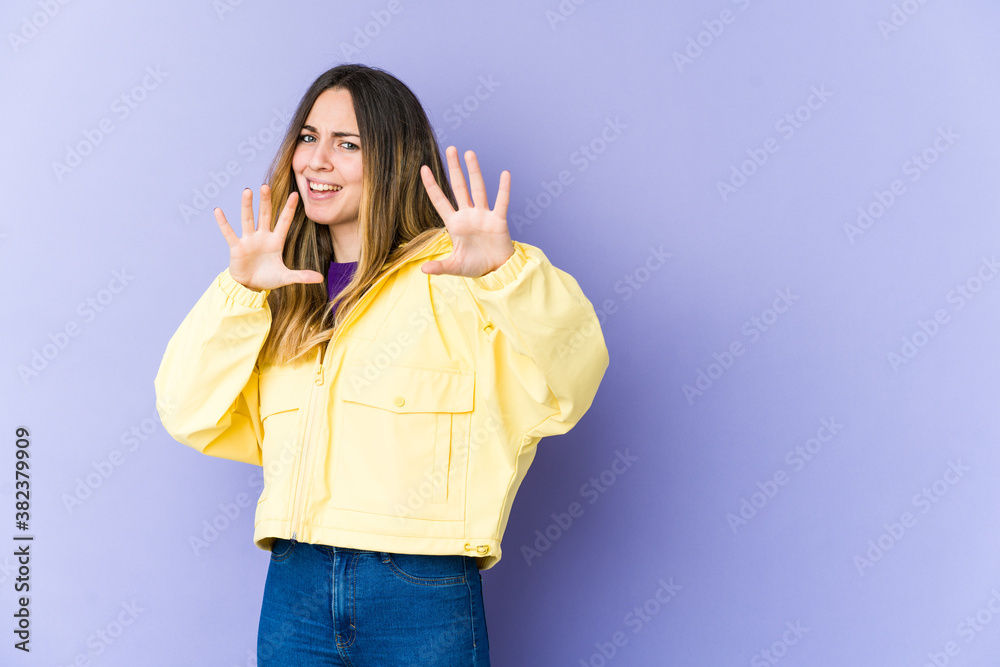 Young caucasian woman isolated on purple background upset screaming with tense hands. Young caucasian woman isolated on purple background upset screaming with tense hands.