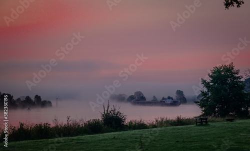ship transport sunrise over the river maas in Holland photo