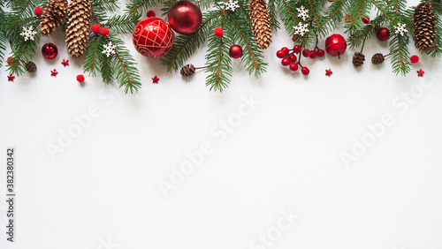 Christmas or new year background,simple composition of christmas decoration red balls,cones,snowflakes and fir branches on white background,flat lay,empty space for greeting text,copy spaes