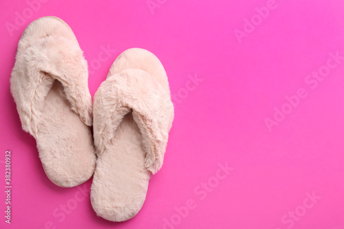 Pair of stylish soft slippers on pink background, flat lay. Space for text