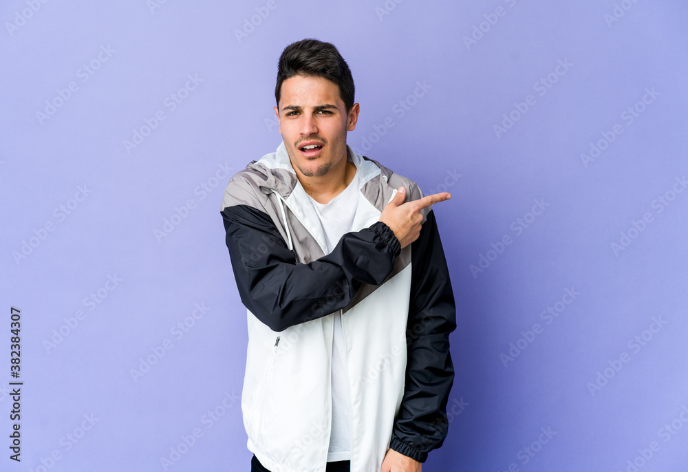 Young caucasian man isolated on purple background pointing to the side Young caucasian man isolated on purple background pointing to the side