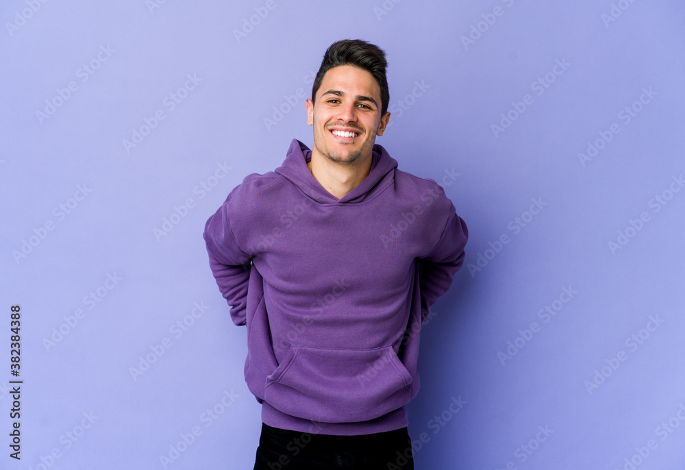 Obraz premium Young caucasian man isolated on purple background happy, smiling and cheerful.