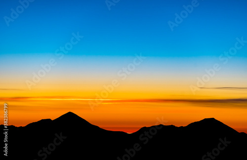 Silhouettes and ridges of mountains in the evening, during sunset