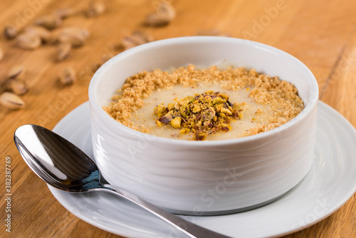 Turkish Desserts milk puding; Keskul, sutlac on wood board photo