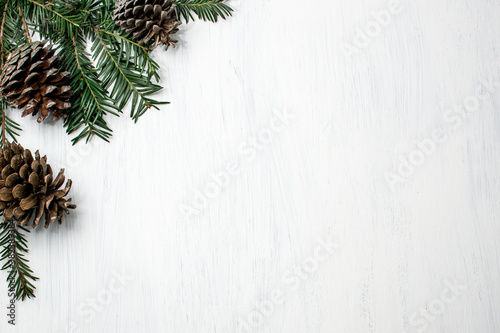 Christmas winter white background. Pinecones and pine branches on corner. Noel photo