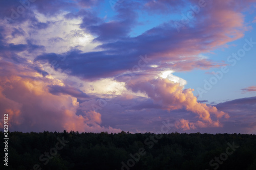 There are dramatic clouds in the dark sky as the sun sets. The sky is dominated by fuchsia, pink.