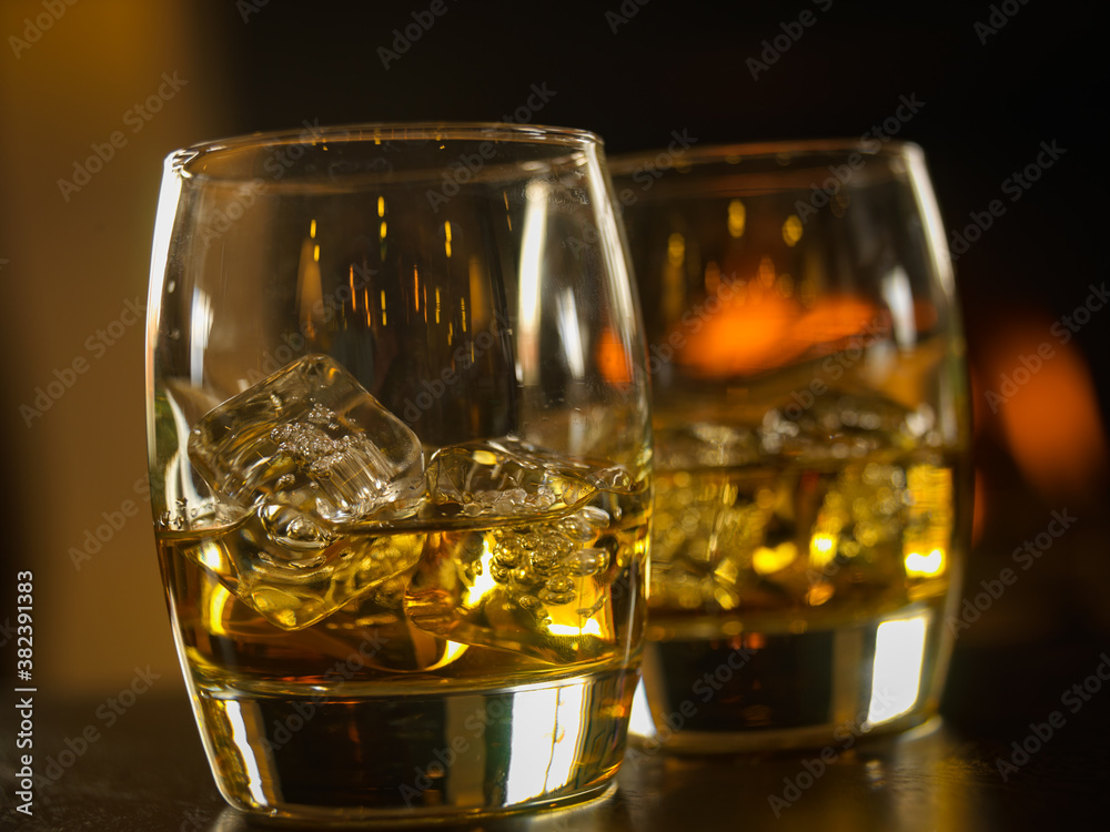 scotch whisky glassees with decanter and fire in background scotch whisky glassees with decanter and fire in background