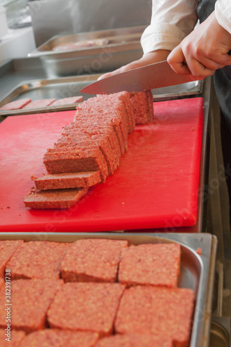 Chef preparing traditional Scottish square or lorne sausage photo