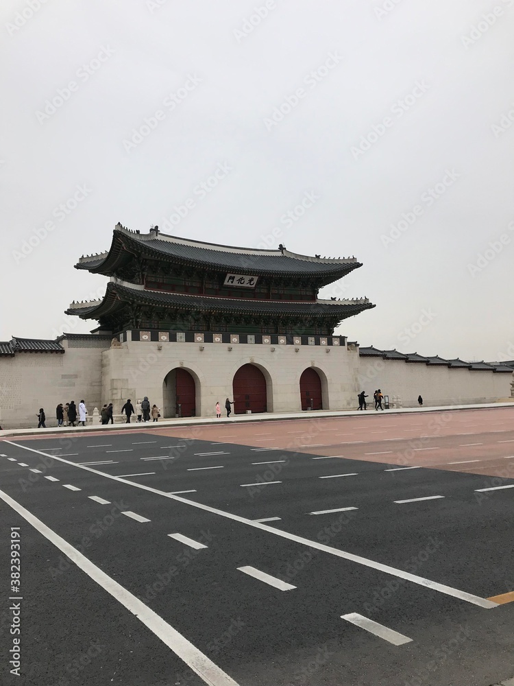 Fototapeta premium Gwanghwamun Gate traditional building, structure gray sky with tree