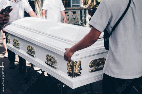 Close up of pallbearers guiding the casket out during funeral procession. Selective focus