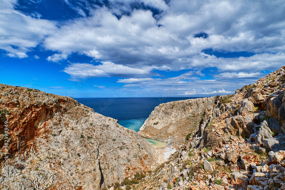 Rocky red cliffs of typical Greek view, azure sea, clear blue sky, beautiful sky. Stefanou beach, Seitan Limania, Akrotiri peninsula, Crete, Greece