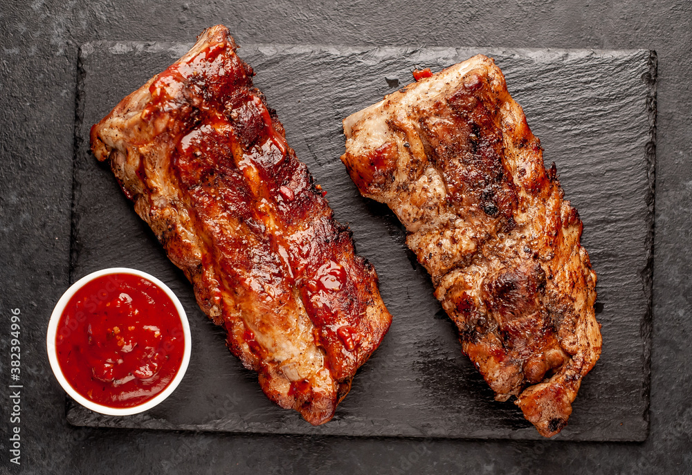 grilled pork ribs with spices on a stone background