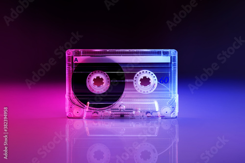 Photographie Retro audio cassette tape lit by pink and blue lamps on a black background with