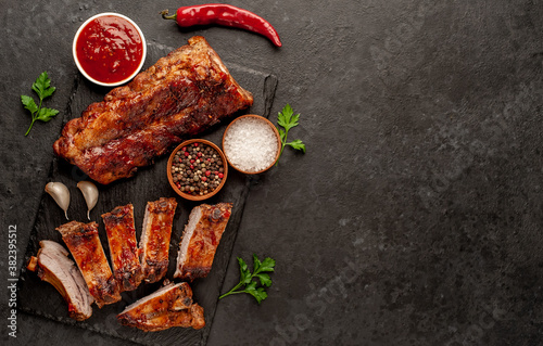 Fotografie, Obraz grilled pork ribs with spices on a stone background with copy space for your te
