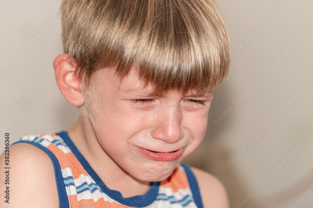 The boy sits and cries on the couch with tears after punishment. The boy sits and cries on the couch with tears after punishment.