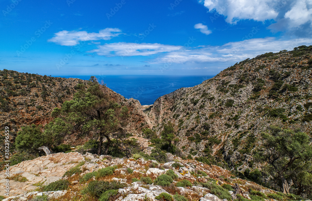 Typical Greek landscape, hill, spring foliage, bushes, olive trees. Clear blue sky, beautiful clouds. Akrotiri peninsula, Chania region, Crete, Greece
