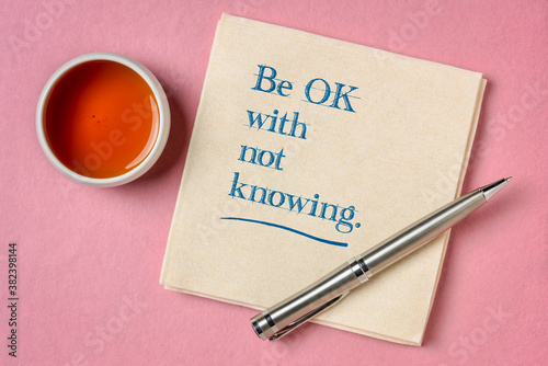 be OK with not knowing inspirational advice - handwriting on napkin with a cup of tea, unknown uncertainty and stress concept