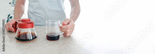 Freshly brewed coffee in glass server and glass cup on table. Pourover, V60. photo