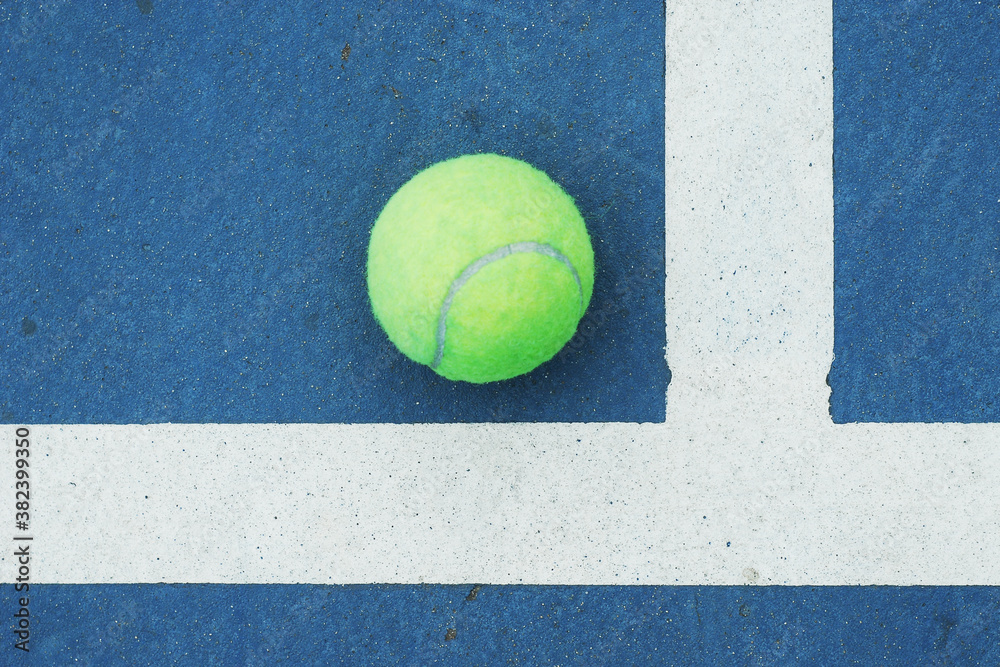 Tennis ball on concrete blue field with white line