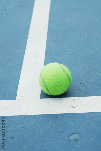 Tennis ball on concrete blue field with white line