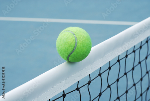 Tennis ball on net  with concrete blue field and white line © yoki5270