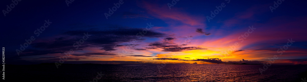 Panorama Beautiful colorful sunset at the sea with dramatic clouds and sun shining.
