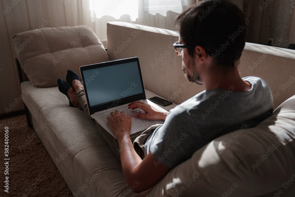 Remote Job. Man Working On Laptop Sitting On Sofa At Home. Remote Job. Man Working On Laptop Sitting On Sofa At Home.