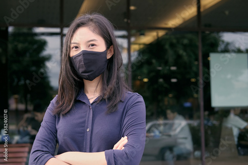 portrait of a woman with fabric mask, restaurant in background 