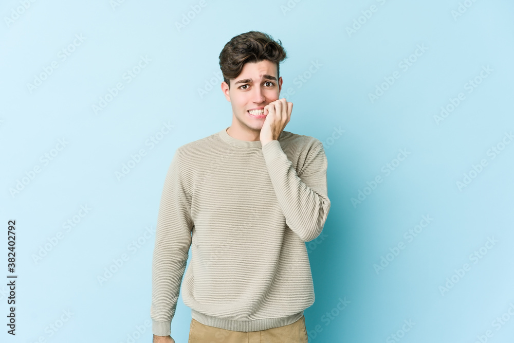 Young caucasian man isolated on blue background biting fingernails, nervous and very anxious. Young caucasian man isolated on blue background biting fingernails, nervous and very anxious.
